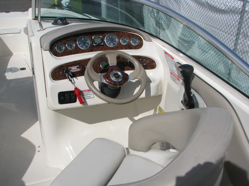 Slide: The Image of 2003 Sea Ray 240 Sundeck boat dashboard with steering wheel and control panel. - 7