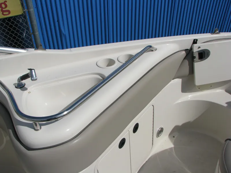 Slide: The Image of 2003 Sea Ray 240 Sundeck interior with sink and cup holders, featuring sleek design elements. - 9