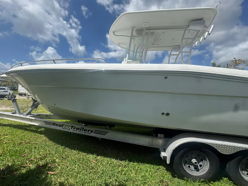 Slide: The Image of 1997 Stamas 290 Tarpon boat on trailer under a partly cloudy sky. - 13