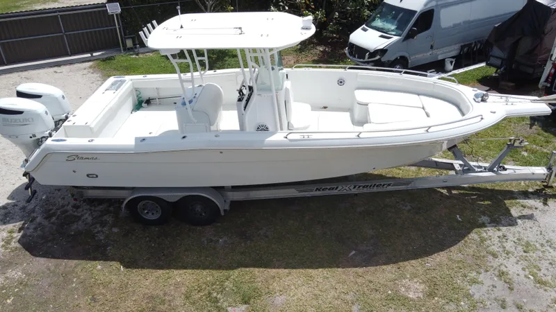 Slide: The Image of 1997 Stamas 290 Tarpon boat on trailer, parked outdoors. - 14