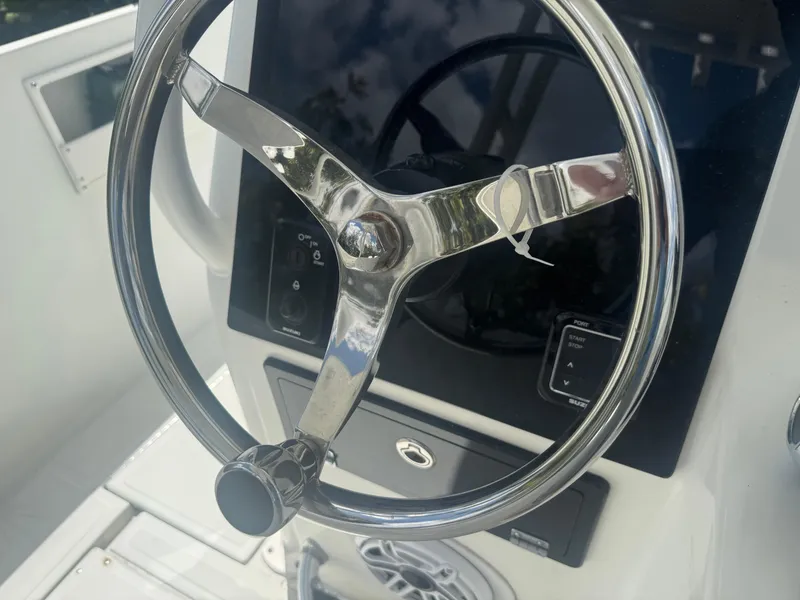 Slide: The Image of Steering wheel of a 1997 Stamas 290 Tarpon boat, featuring a sleek chrome design. - 19
