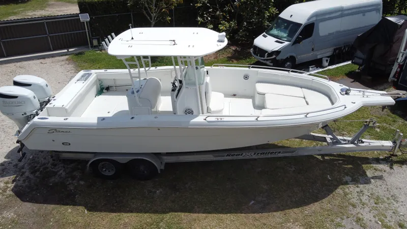 Slide: The Image of 1997 Stamas 290 Tarpon boat on trailer, parked outdoors, with twin engines. - 2