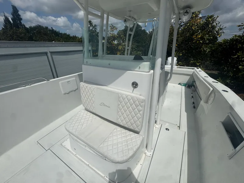 Slide: The Image of 1997 Stamas 290 Tarpon boat interior with white seating and console under a cloudy sky. - 26