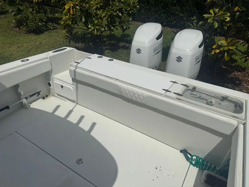 Slide: The Image of 1997 Stamas 290 Tarpon boat deck with Suzuki outboard motors in a garden setting. - 29