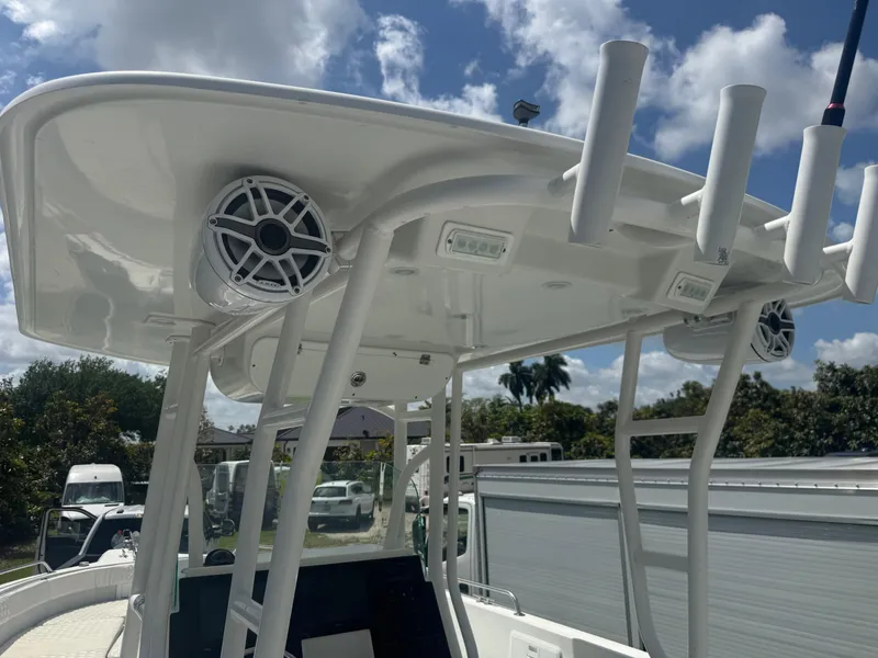 Slide: The Image of 1997 Stamas 290 Tarpon boat with T-top, speakers, and rod holders under a blue sky. - 32
