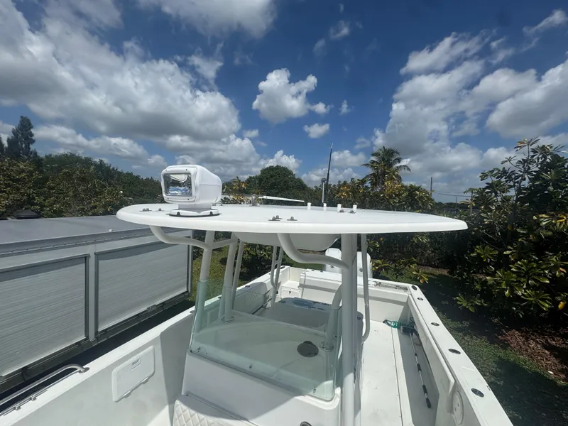 Slide: The Image of 1997 Stamas 290 Tarpon boat under a partly cloudy sky, featuring a sleek white design. - 35