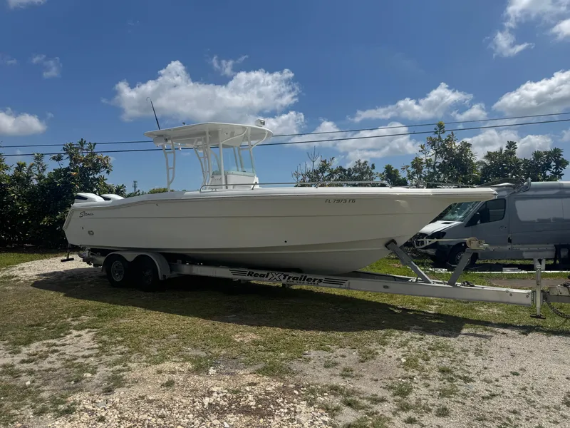 Slide: The Image of 1997 Stamas 290 Tarpon boat on trailer under clear blue sky. - 4