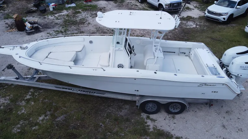 Slide: The Image of 1997 Stamas 290 Tarpon boat on trailer, white exterior, parked outdoors. - 5