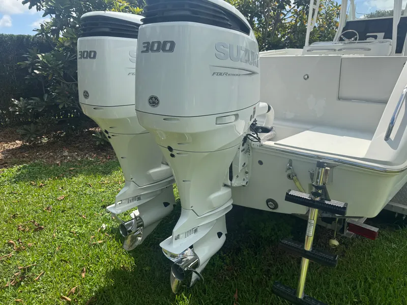 Slide: The Image of 1997 Stamas 290 Tarpon boat with twin Suzuki 300 outboard motors on grassy area. - 9