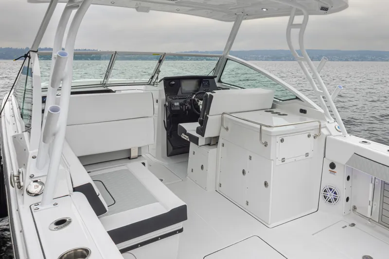 Slide: The Image of 2024 Blackfin 272 DC boat interior with seating and helm, on calm water. - 10