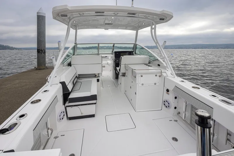 Slide: The Image of 2024 Blackfin 272 DC boat interior with seating and storage, docked by the water. - 11