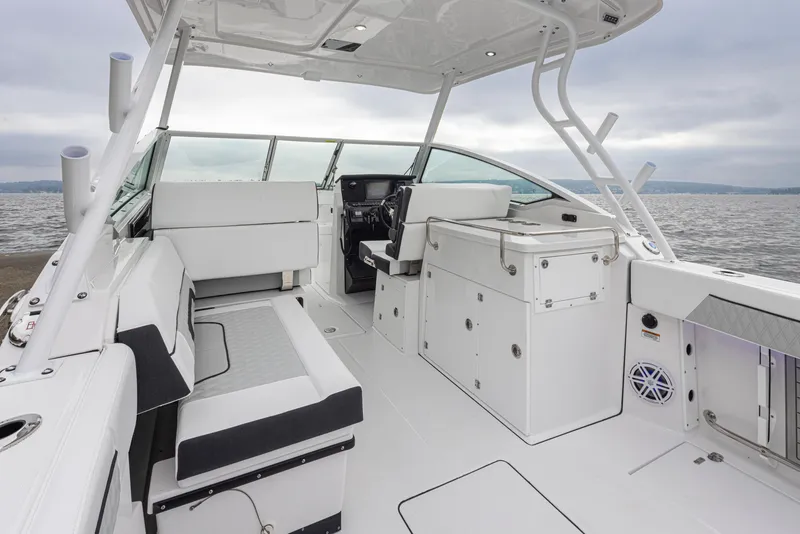 Slide: The Image of 2024 Blackfin 272 DC boat interior with seating and storage, on a calm water backdrop. - 12