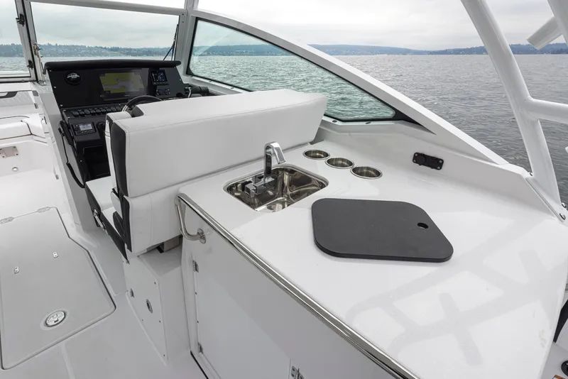 Slide: The Image of 2024 Blackfin 272 DC boat interior with helm, sink, and cup holders. - 14
