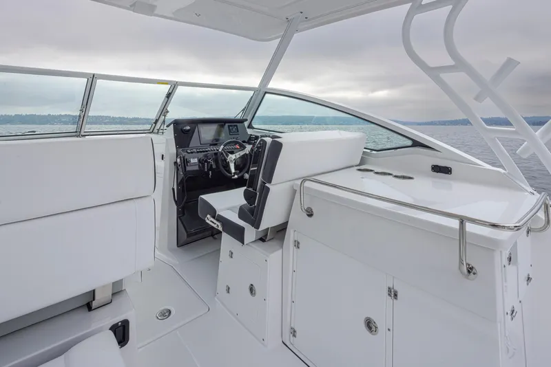 Slide: The Image of 2024 Blackfin 272 DC boat interior with sleek white seating and modern helm. - 16