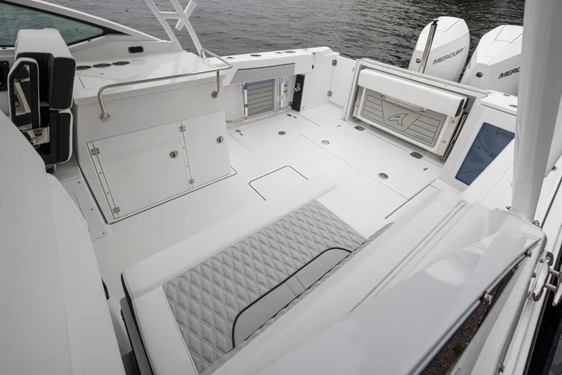 Slide: The Image of 2024 Blackfin 272 DC boat interior with sleek seating and storage, docked by the water. - 22