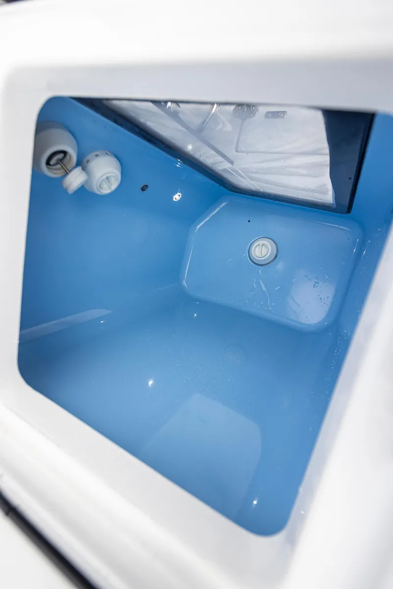 Slide: The Image of 2024 Blackfin 272 DC boat interior compartment with blue lining and drainage system. - 26