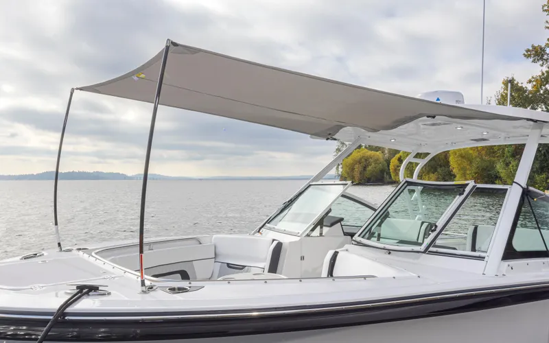Slide: The Image of 2024 Blackfin 272 DC boat with canopy on calm water, showcasing sleek design. - 34
