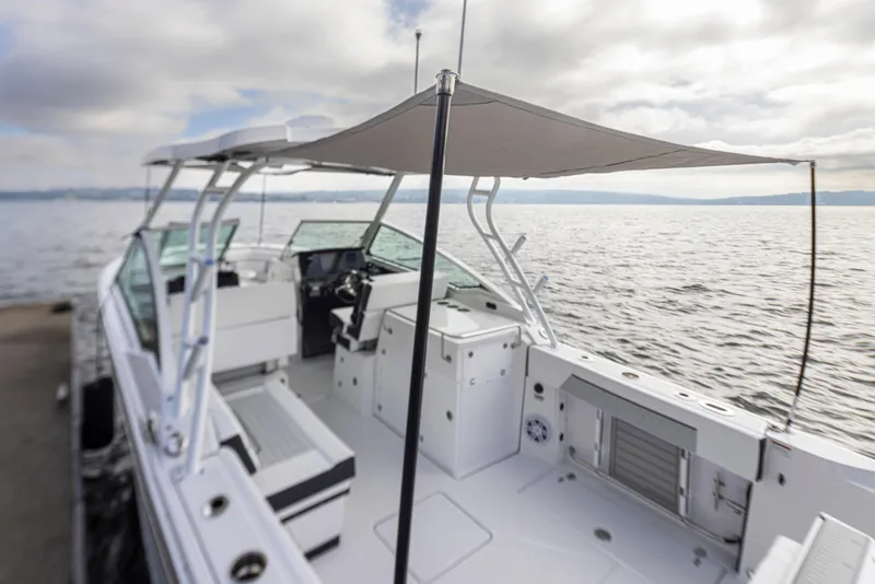 Slide: The Image of 2024 Blackfin 272 DC boat with canopy, docked by the water on a cloudy day. - 39