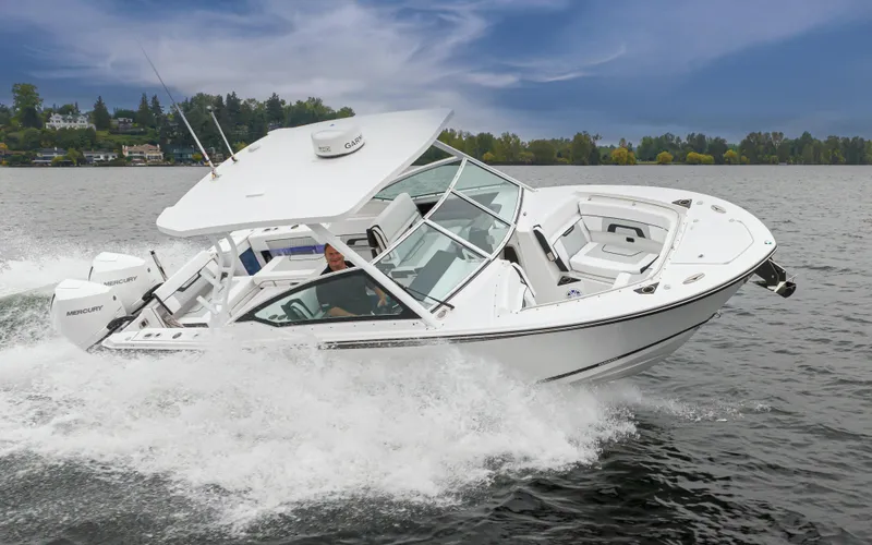 Slide: The Image of 2024 Blackfin 272 DC boat cruising on a lake with scenic background. - 4