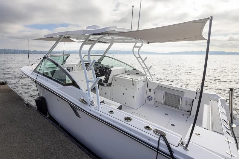 Slide: The Image of 2024 Blackfin 272 DC boat docked by the water, showcasing sleek design and spacious deck. - 41