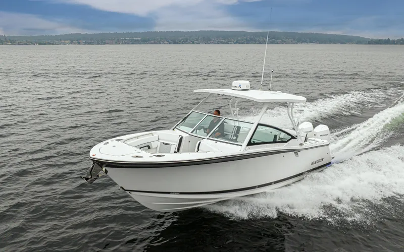 Slide: The Image of 2024 Blackfin 272 DC boat cruising on open water under a cloudy sky. - 44