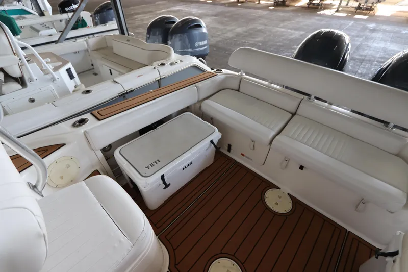 Slide: The Image of 2016 Robalo R265 Walkaround boat interior with seating and Yeti cooler. - 11