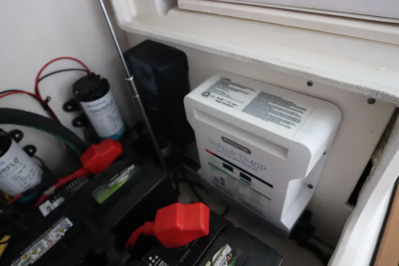 Slide: The Image of Electrical components in a 2016 Robalo R265 Walkaround boat, featuring batteries and wiring. - 13