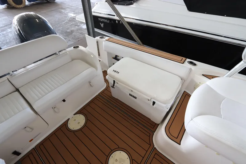 Slide: The Image of 2016 Robalo R265 Walkaround boat interior with seating and Yeti cooler. - 15