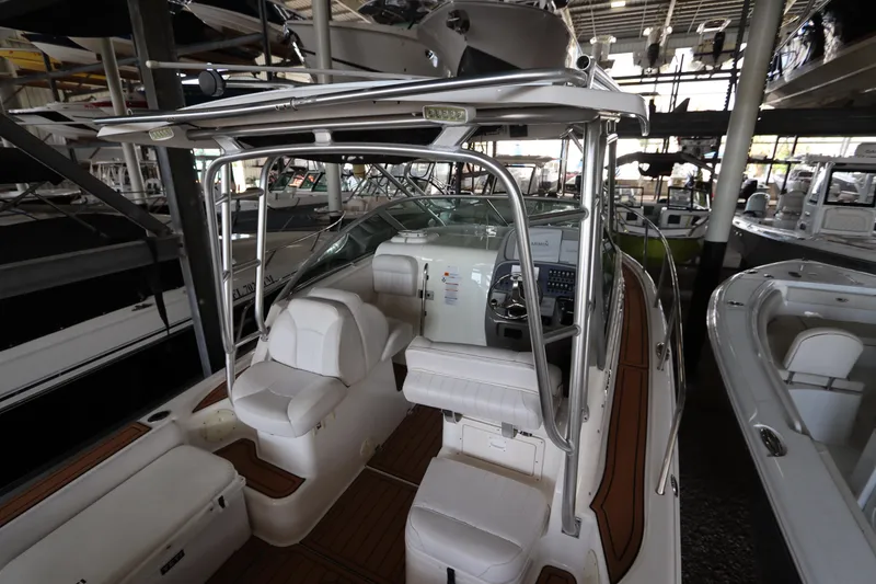 Slide: The Image of 2016 Robalo R265 Walkaround boat interior with seating and control panel in a showroom. - 17
