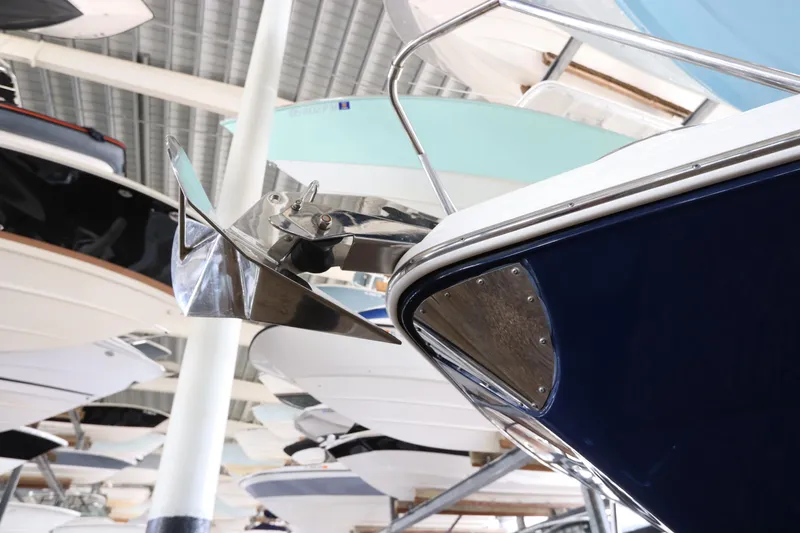 Slide: The Image of 2016 Robalo R265 Walkaround boat with stainless steel anchor in indoor storage. - 2