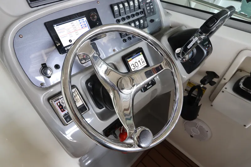 Slide: The Image of 2016 Robalo R265 Walkaround helm with steering wheel, controls, and navigation display. - 28