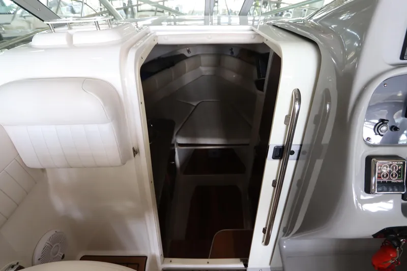 Slide: The Image of 2016 Robalo R265 Walkaround cabin interior with white seating and wooden flooring. - 38