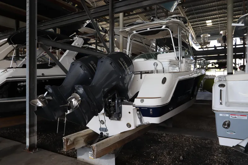 Slide: The Image of 2016 Robalo R265 Walkaround boat with dual outboard motors in storage facility. - 4