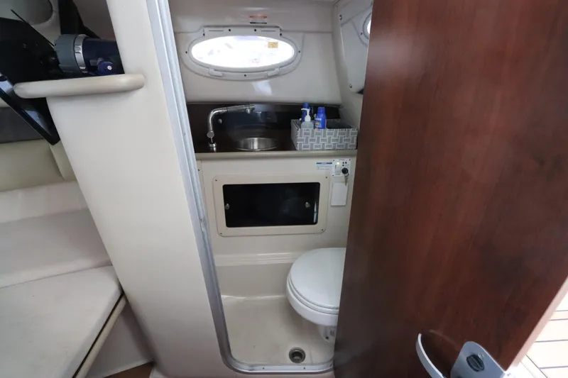 Slide: The Image of 2016 Robalo R265 Walkaround boat interior with compact bathroom and sink. - 43