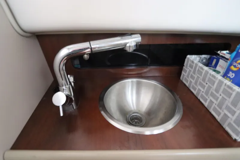 Slide: The Image of Stainless steel sink and faucet in 2016 Robalo R265 Walkaround boat interior. - 44