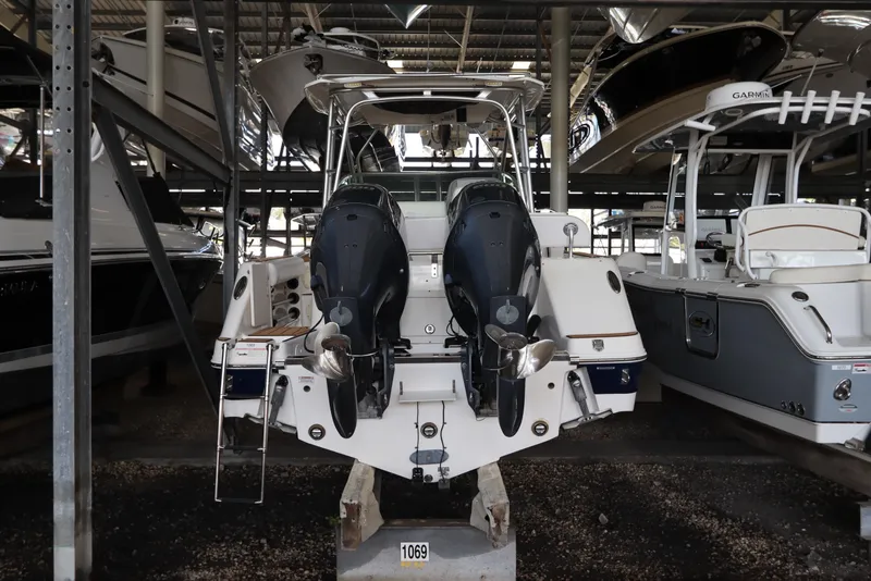 Slide: The Image of 2016 Robalo R265 Walkaround boat with dual engines in a storage facility. - 5