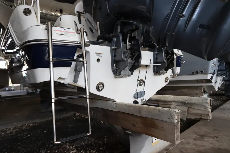 Slide: The Image of 2016 Robalo R265 Walkaround boat on dry dock with ladder and dual outboard motors. - 6