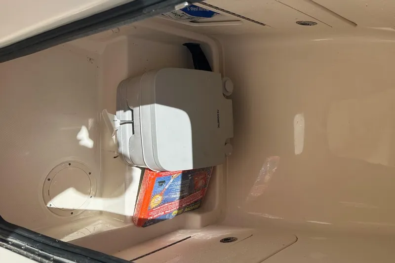 Slide: The Image of Storage compartment in a 2022 Grady-White 236 Fisherman boat, featuring a portable toilet. - 15
