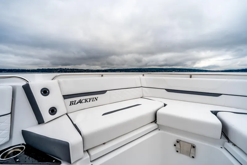 Slide: The Image of 2023 Blackfin 252 CC boat interior with white seating and overcast sky. - 13
