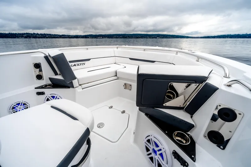 Slide: The Image of 2023 Blackfin 252 CC boat interior with seating and speakers on a calm lake. - 21