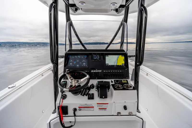 Slide: The Image of 2023 Blackfin 252 CC boat dashboard with navigation screens on calm water. - 4