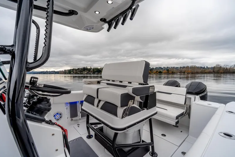 Slide: The Image of 2023 Blackfin 252 CC boat interior with seating, steering wheel, and lake view. - 6