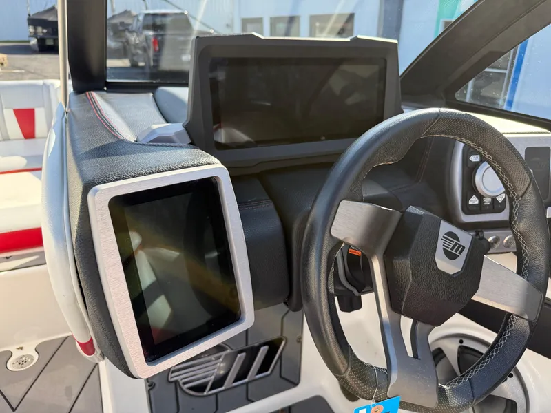 Slide: The Image of 2021 Malibu Wakesetter 23 LSV dashboard with steering wheel and touchscreen displays. - 17