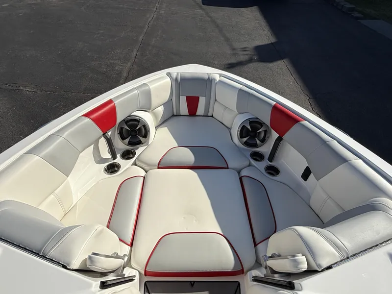 Slide: The Image of 2021 Malibu Wakesetter 23 LSV boat interior with white and red seating, speakers, and cup holders. - 23