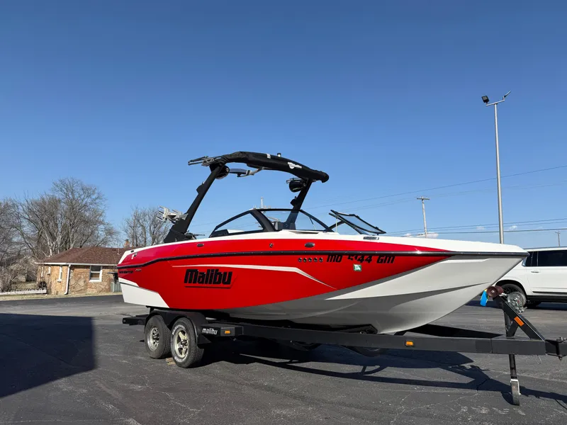Slide: The Image of 2021 Malibu Wakesetter 23 LSV boat on trailer, red and white design, parked outdoors. - 3