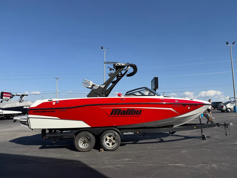 Slide: The Image of 2021 Malibu Wakesetter 23 LSV boat in red on a trailer, parked outdoors. - 4