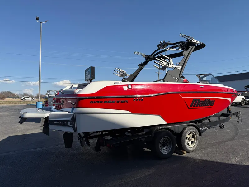 Slide: The Image of 2021 Malibu Wakesetter 23 LSV boat on trailer, red and white design, parked outdoors. - 6