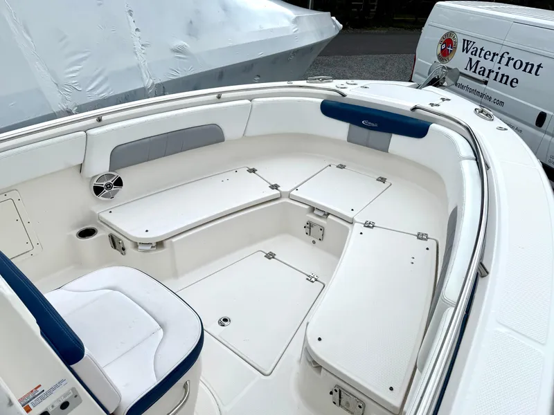 Slide: The Image of 2020 Robalo R242 Explorer boat interior with white seating and storage compartments. - 27