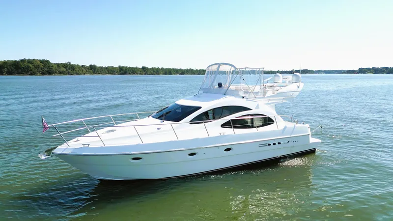 Slide: The Image of 2002 Azimut 42 yacht cruising on a serene lake under clear skies. - 2