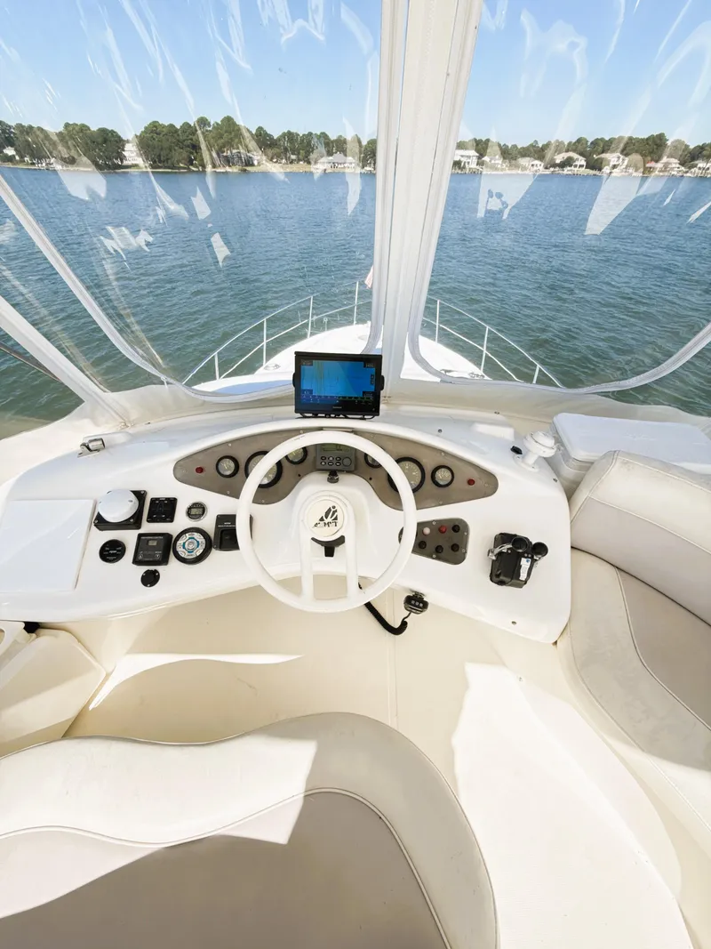 Slide: The Image of 2002 Azimut 42 yacht helm with navigation controls, overlooking serene waters. - 25